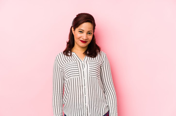 Fototapeta premium Middle age latin woman isolated on a pink background happy, smiling and cheerful.