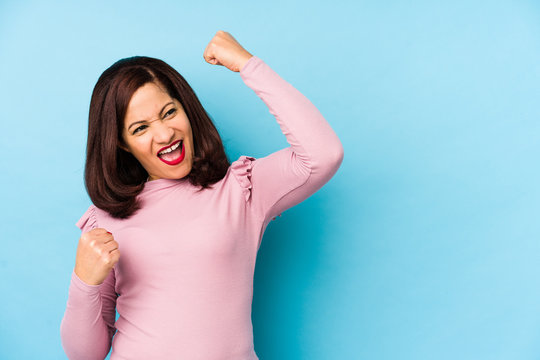 Middle Age Latin Woman Isolated Raising Fist After A Victory, Winner Concept.