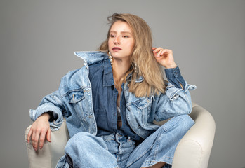 Beautiful woman in jeans and a denim shirt in studio