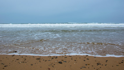 Sandy beach and rocks by the sea shore landscape background. California sandy beach coast seashore waves and tide wallpaper
