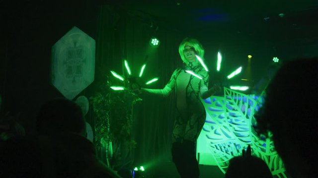 Psychedlic looking female performer spinning multiple neon led lights in front of crowd - Slow Motion  - shot on RED