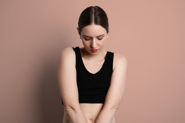 Fototapeta premium Young woman wearing casual black underwear looking down and posing in the studio. 
