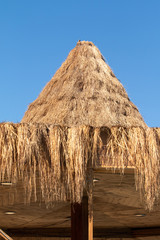 Thatched roof umbrella. Full frame of hanging straw under the roof.