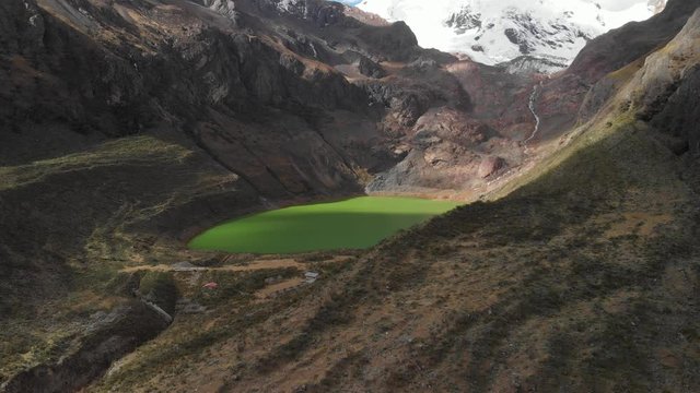 Green lake in the peruvian andes, slow fly