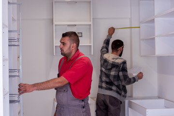 workers installing a new kitchen - Powered by Adobe