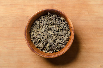 Green tea. Natural leaf of Chinese tea. Ingredient in a clay cup. Antioxidant and healthy life.