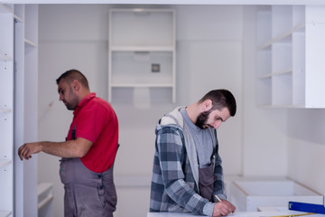 Naklejka na ściany i meble workers installing a new kitchen