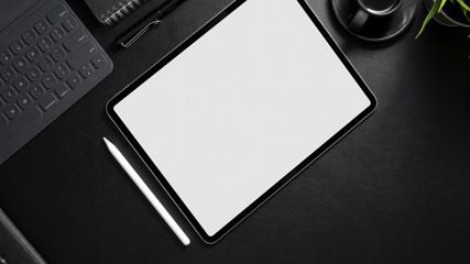 Top view of dark workspace with mock- up digital tablet, stylus