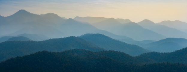 Amazing wild nature view of layer of mountain forest landscape with cloudy sky. Natural green scenery of cloud and mountain slopes background. Maehongson,Thailand. Panorama view.