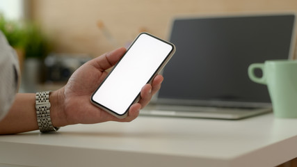 Cropped shot of male freelancer holding blank screen smartphone