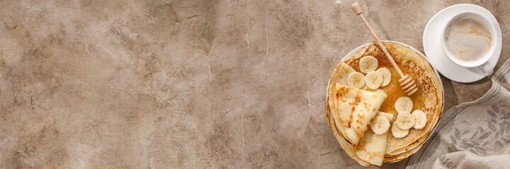 Delicious homemade pancakes with honey on a textural background. Top view, close-up. Traditional...