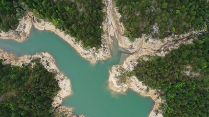 Aerial top down view of Lake Grahovo in mountains. Beautiful landscape of Montenegro nature. Emerald water of Grahovsko Jezero. Sand and stone coast. Forest with green trees. Niksic, Montenegro.