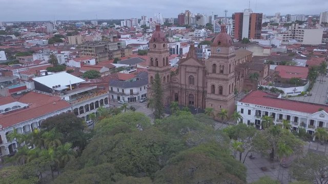 Aerial view of the city of Santa Cruz de la Sierra. Camera orbits around Cathedral Basilica of St. Lawrence. Clip without any type of color grading and is in the flat profile