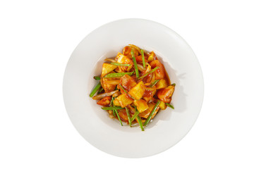 vegetable stew portion of side dish on a plate on white isolated background view from above. Appetizing dish for the menu restaurant, bar, cafe