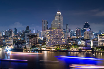 Bangkok city skyline at night among Chao Phraya River.