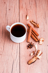 Obraz na płótnie Canvas Fragrant natural custard coffee with cinnamon sticks, dried mushrooms, on a wooden background.