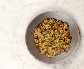 Pilaf with liver and oyster mushrooms on a plate on a light background. Top view, flat lay..