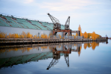 Fototapeta na wymiar Old magazine building and harbor cranes in Gavle, Sweden.