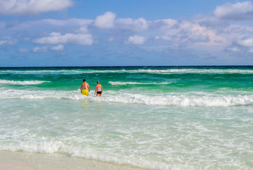 Fototapeta na wymiar Couple walking into the ocean
