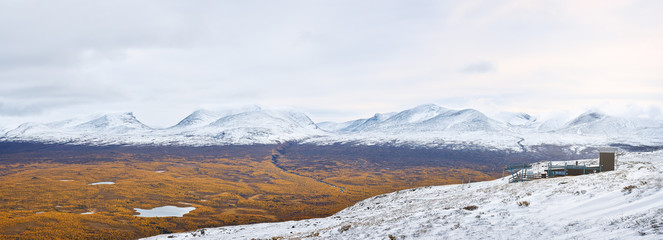 Panoramic view from Nuolja mountain top with Aurora Sky Station and surrounding Abisko national park mountain area.