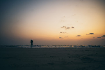 silhouette of the lonely man and the sea during sunset