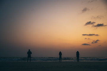 Silhouette of a group of friends Seaside during sunset