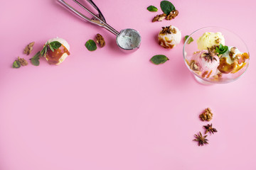 Delicious fragrant ice cream with nuts and mint on a pink background.