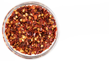 crushed red chili pepper in glass bowl.  Top View on white background