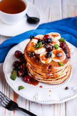 Pancakes with homemade caramel fresh berries and mint leaves. Food