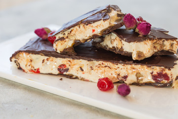 Delicious traditional Italian festive torrone or nougat with nuts on stone background. Holiday concept.