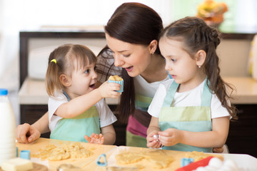 Fototapeta premium Mother and children weared aprons making together cookies