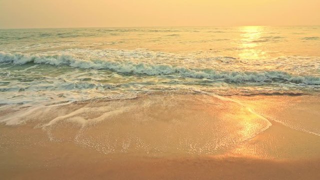 Small ocean sea waves on sandy beach with sunrise sunset. Background landscape picture of dusk or dawn at the ocean beach with small waves at low tide. Background wallpaper picture.