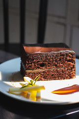 a piece of chocolate cake on decorate plate with natural light