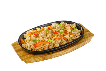 Vegetarian rice with vegetables, peppers, bell peppers, soy meat serving on a hot frying pan, on a wooden board on white isolated background side view. For the menu, restaurant, bar, cafe