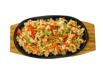 Vegetarian rice with vegetables, peppers, bell peppers, soy meat, serving on a hot frying pan, on a wooden board on white isolated background view from above. For the menu, restaurant, bar, cafe