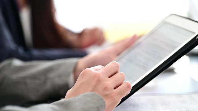 会議でタブレットの操作をする女性