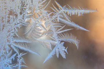 frosty patterns on the window glass closeup. natural textures and backgrounds. ice patterns on...
