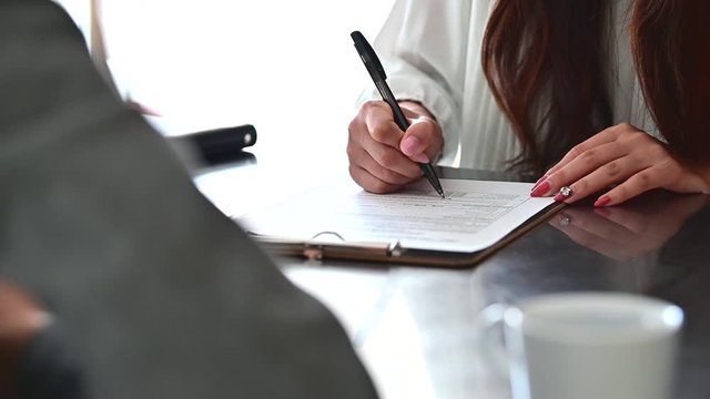 書類に署名する女性の手元