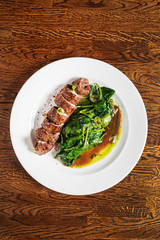 beef with roasted spinach on the wooden background