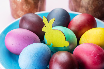 Colorful Easter eggs and Easter bread attributes of Easter celebration. Pink background.