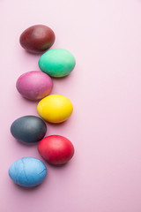 Colorful Easter eggs as an attribute of Easter celebration. Pink background.