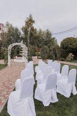 wedding ceremony arch decorated with flowers with chairs