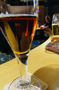 Ein Bierglas mit Dunkelbier steht auf einer Theke in einer Kneipe
