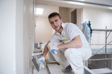 construction worker plastering on gypsum walls