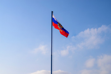 Flag of Russia is developing on the flagpole. Colors - red, white, blue. Wind, the clouds.