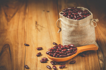Red beans placed in a sack on a wooden floor