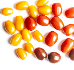 Vegetables, red, yellow and dark cherry tomatoes on a white background