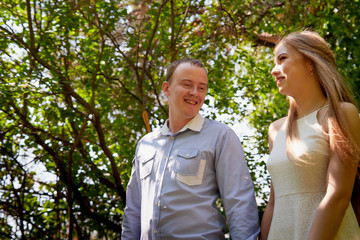 Young man and woman couple walk in the park. Spring or summer love story. Young happy family