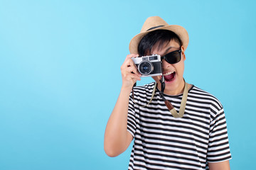 Young Asian travelers are taking pictures in the blue studio. Isolated background