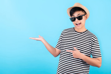 Asian travelers are happy and smiling, with open palms in the blue studio background